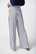 Load image into Gallery viewer, Stylish woman donning striped pants and a black and white striped shirt, epitomizing fashion-forward attire with a touch of class.