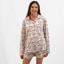 Load image into Gallery viewer, A person wearing a multicolored flannel sleep set with a Christmas-themed pattern, including the text 'FaLaLa' and 'hope'.
