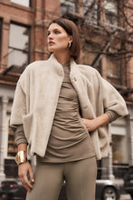 Load image into Gallery viewer, Timeless jersey knit top with a wrap neckline and long sleeves, enhanced by side shirring for a chic, fitted look suitable for any occasion.

