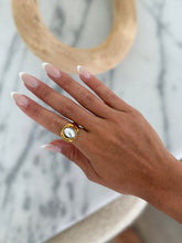 Load image into Gallery viewer, A gold ring with a large, glossy pearl, creating an elegant and sophisticated impression.
