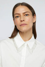 Load image into Gallery viewer, A luxurious white shirt with delicate beading, complemented by a stylish grey skirt, epitomizing refined elegance.
