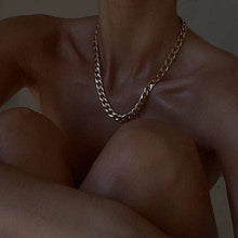 Load image into Gallery viewer, A stylish woman wearing a bold gold chain necklace that effortlessly elevates her outfit. Measures 40cm long and 1cm wide.
