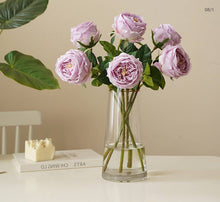 Load image into Gallery viewer, A vase with purple Real Touch roses on a table, showcasing the elegance of artificial flowers in floral designs and wedding bouquets.
