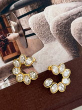 Load image into Gallery viewer, Circular, flower-shaped gold earring with seven sparkling white gemstones. The tone is elegant and stylish.
