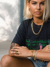 Load image into Gallery viewer, Fashionable woman, showcasing a chunky Cuban chain necklace that enhances her outfit's edgy and modern look.
