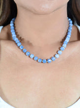 Load image into Gallery viewer, Blue beaded necklace on a person with a white background
