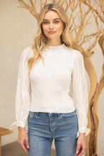 Load image into Gallery viewer, Woman wearing a white blouse and blue jeans with a decorative background
