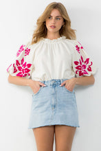 Load image into Gallery viewer, Experience the perfect blend of comfort and style with the Alice Corduroy Top. This white blouse with pink floral patterns is a statement piece, showcasing intricate embroidery on the sleeves.
