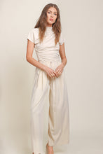 Load image into Gallery viewer, Luxurious Ecru Lennon Pants by Line and Dot worn by the model with a cream top. Classic yet modern design for exquisite style.

